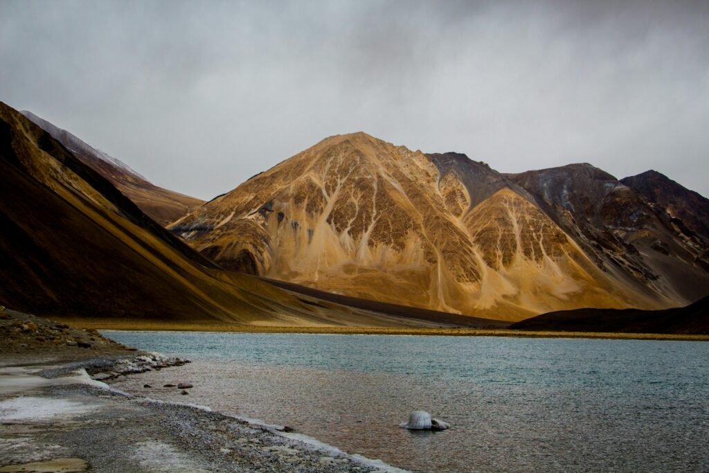 pexels-photo-951927-951927 Majestic view of Pangong Lake with surrounding mountains under cloudy skies in Leh, India.